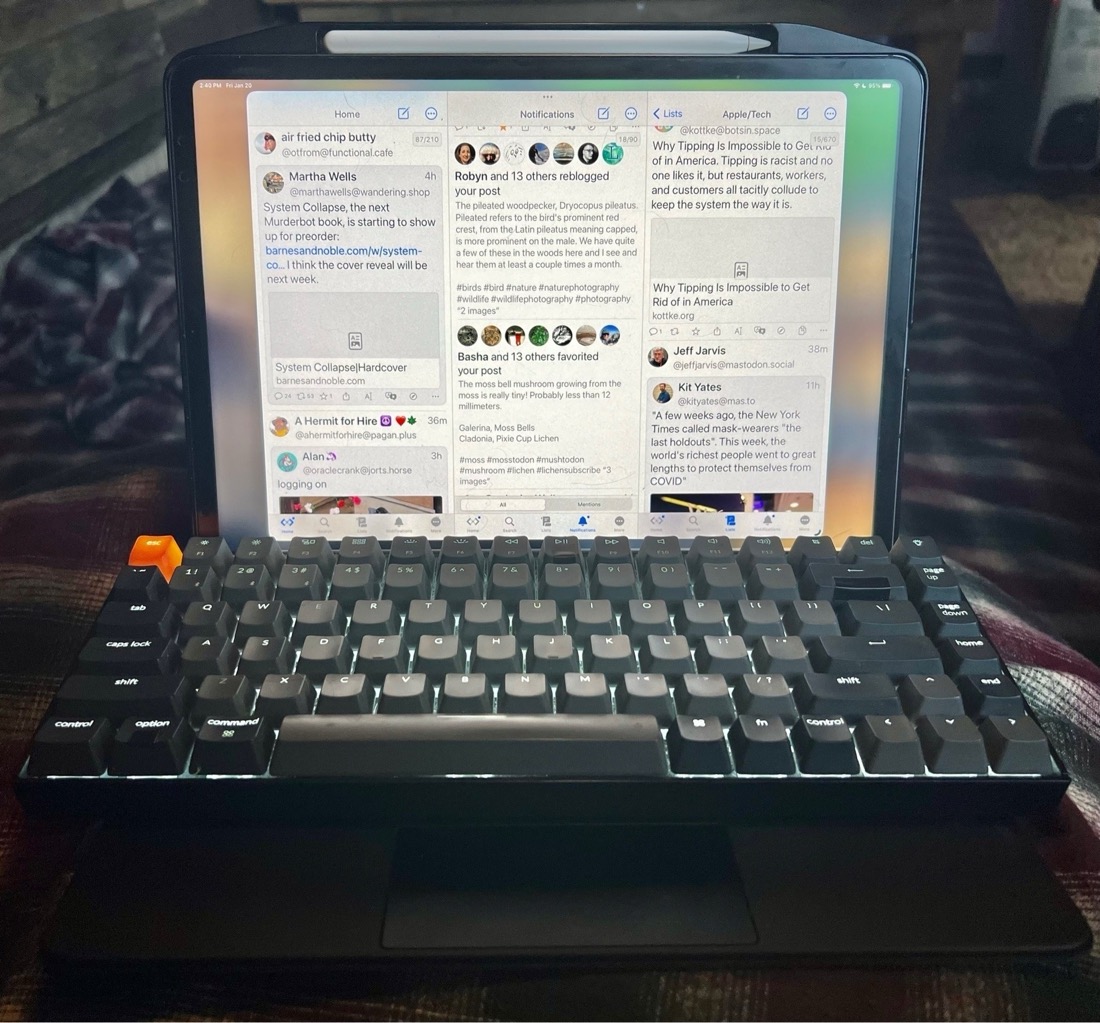 A Keychron mechanical keyboard placed over the keys of a Magic Keyboard with an attached iPad Pro