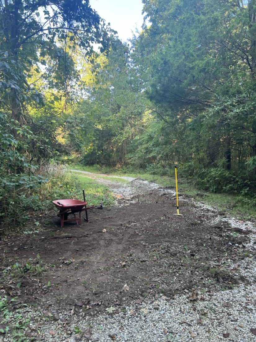 A gravel road being covered in dirt