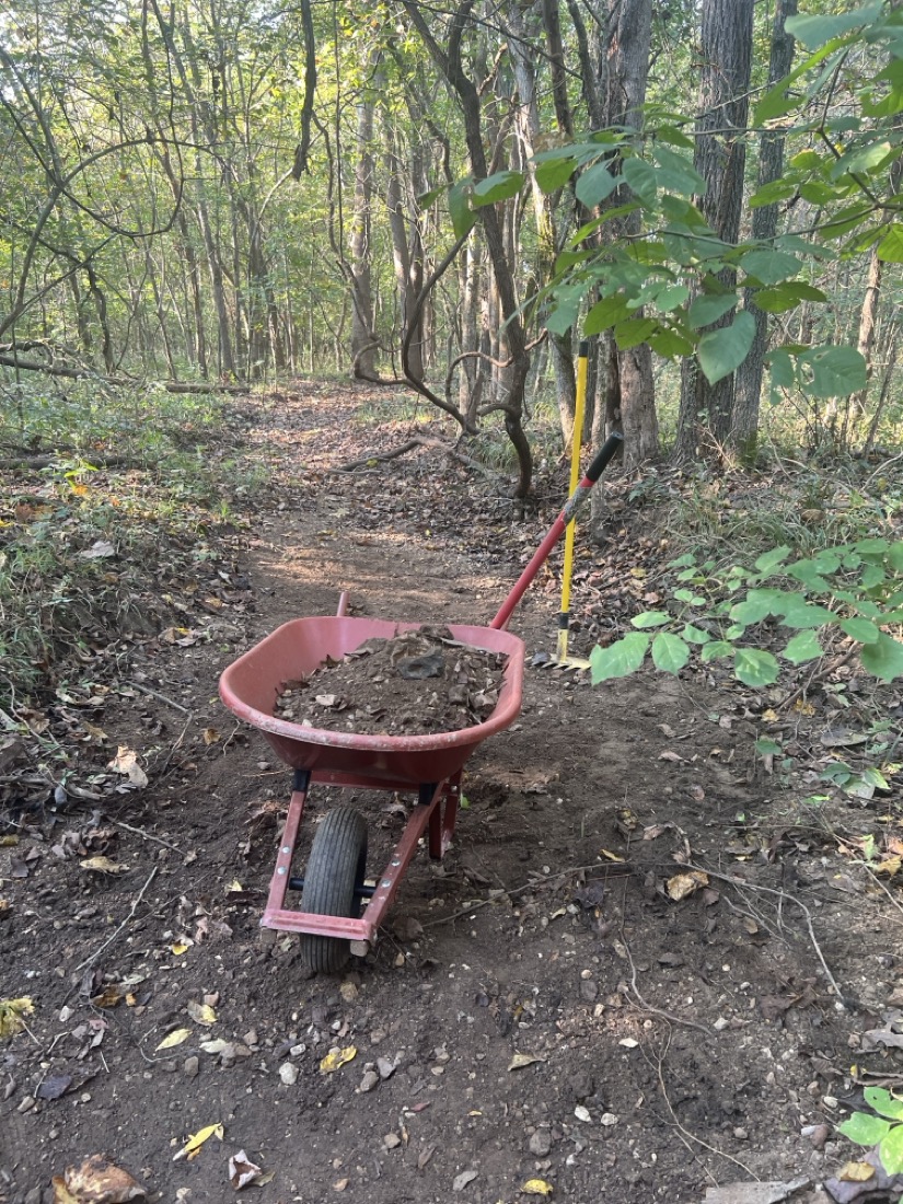 A red wheel barrel filled with sand and gravel