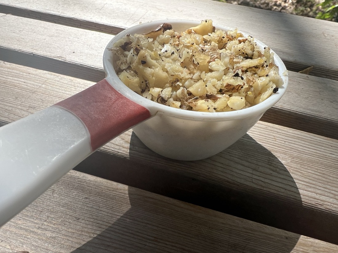 The final result of the process is a small 1/3 measuring cup full of small walnut pieces ready to be used in a recipe.